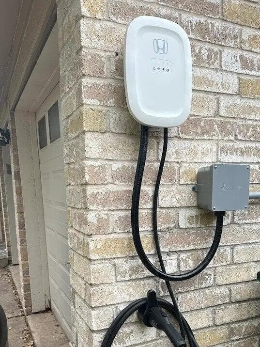 Home EV charger installed beside a garage in Angleton, TX by Ivy Leach Electrical