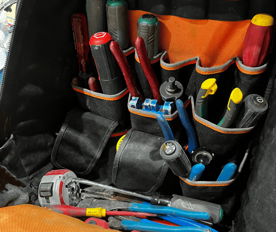 A picture of an electrician's bag full of miscellaneous tools