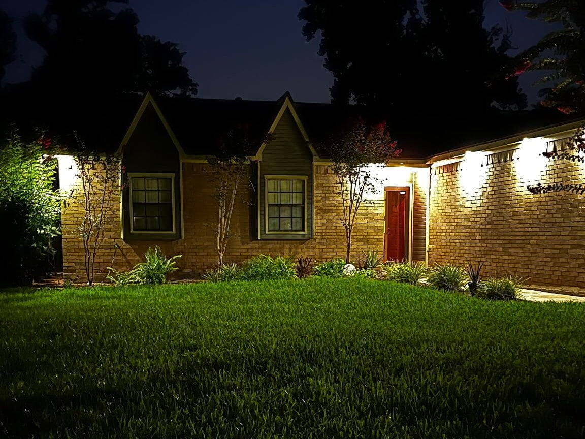 Soffit lighting installed on a brick home in Lake Jackson, TX, lit up at night